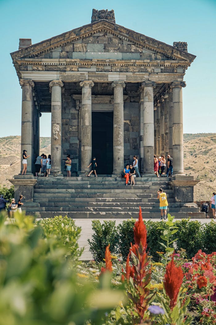 services-01 Visitors explore the historic Garni Temple in Armenia, a stunning example of classical architecture.