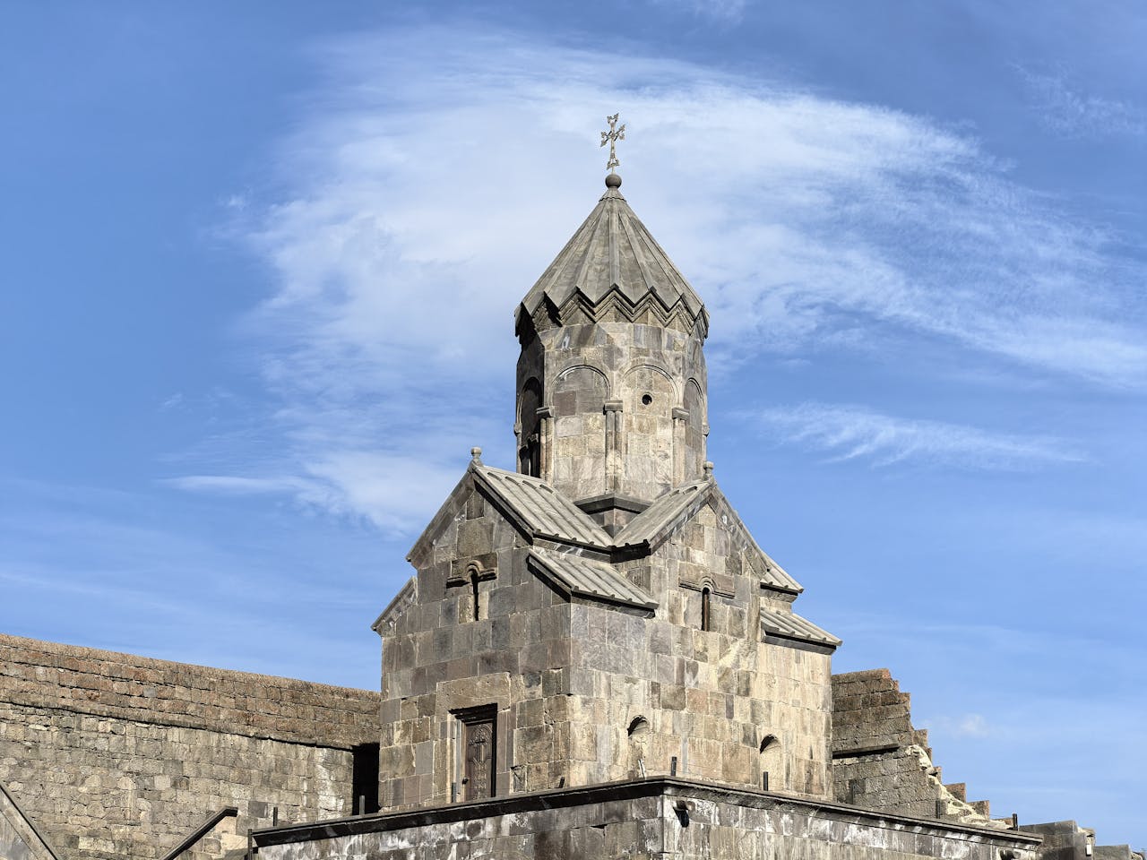 Historic medieval church in Tatev, Armenia under clear blue skies.