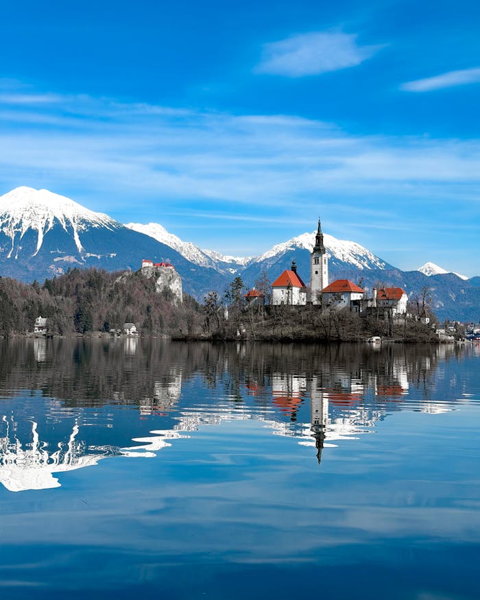Breathtaking view of Lake Bled and Julian Alps reflecting on a clear day.